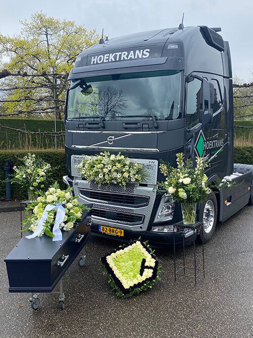 Hoektrans-truck en uitvaartkist Jan Galdon met prachtige bloemen opgesteld voor het Dunweg Uitvaartcentrum