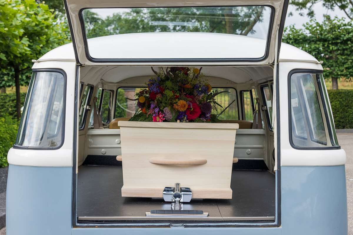 Kist met bloemen in het Volkswagenbusje - bijzonder rouwvervoer